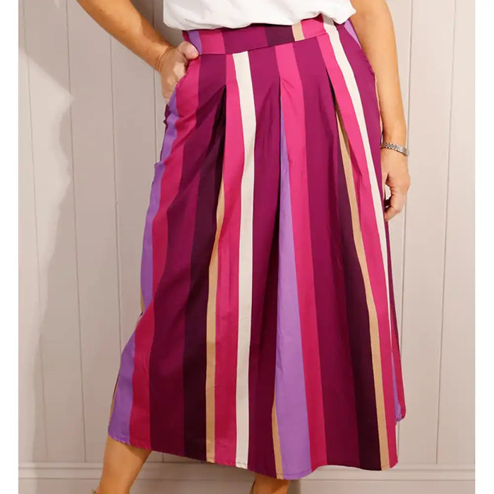 Person wearing a colorful striped skirt against a neutral background