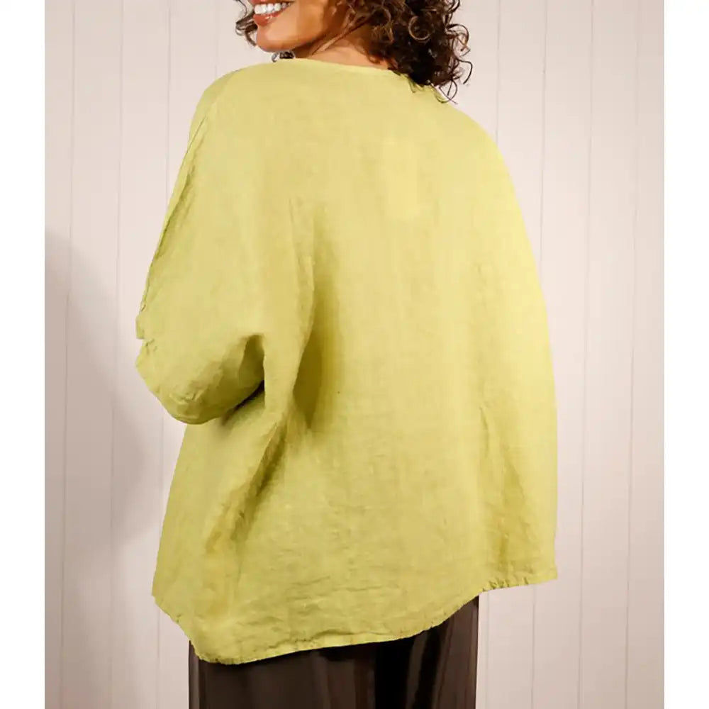Person wearing a light green cardigan against a white background