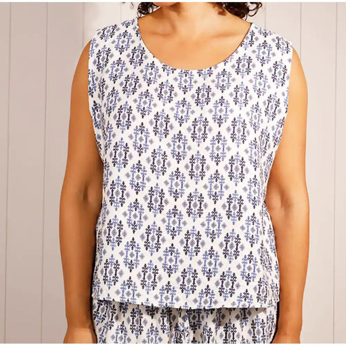 Person wearing a sleeveless top with a floral pattern against a neutral background