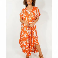Woman wearing an orange dress with an abstract pattern