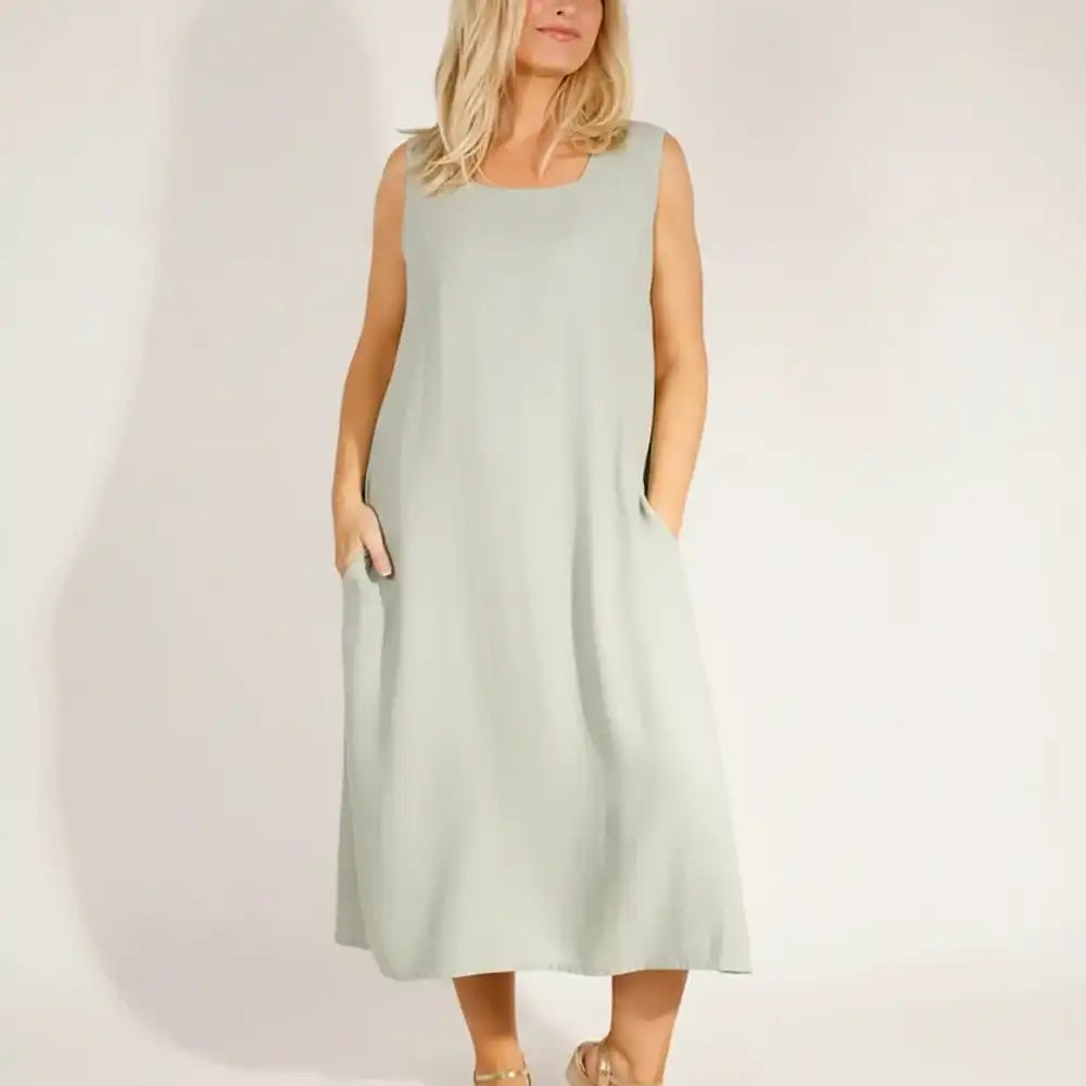 Woman wearing a light green sleeveless dress.
