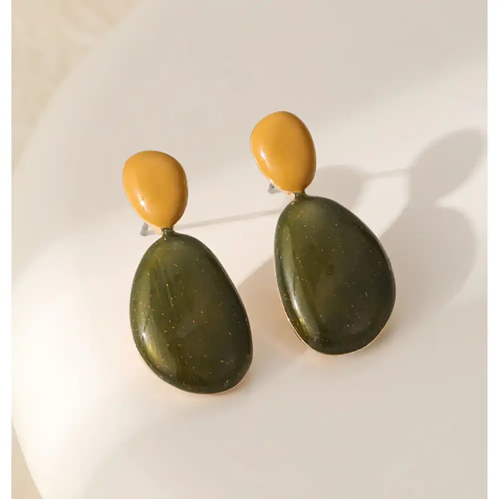 A pair of organic-shaped drop earrings with matte mustard yellow top sections and large dark olive green bottom sections, displayed on a clean white surface.