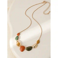 Gold coloured chain leading to pebble shaped gems in orange, sage and mustarf.