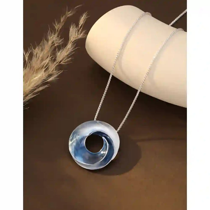 Blue swirl pendant on a silver necklace 