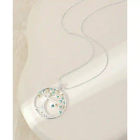 Circle pendant necklace. Pendant has a tree of life with pale blue leaves