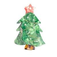 Picture of a Christmas tree hair claw clip  in green with white berries and a red star on top. 