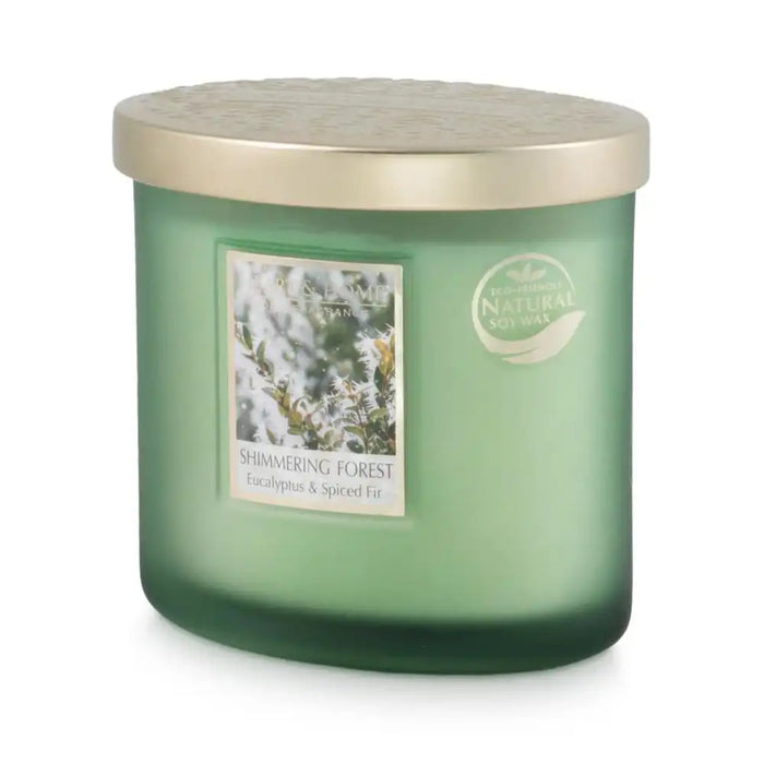 A green glass jar candle with a metallic gold lid, featuring a label that reads 'Shimmering Forest' and 'Eucalyptus & Spiced Fir'.