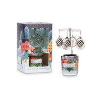 Candle with decorative packaging featuring a winter scene and earrings.