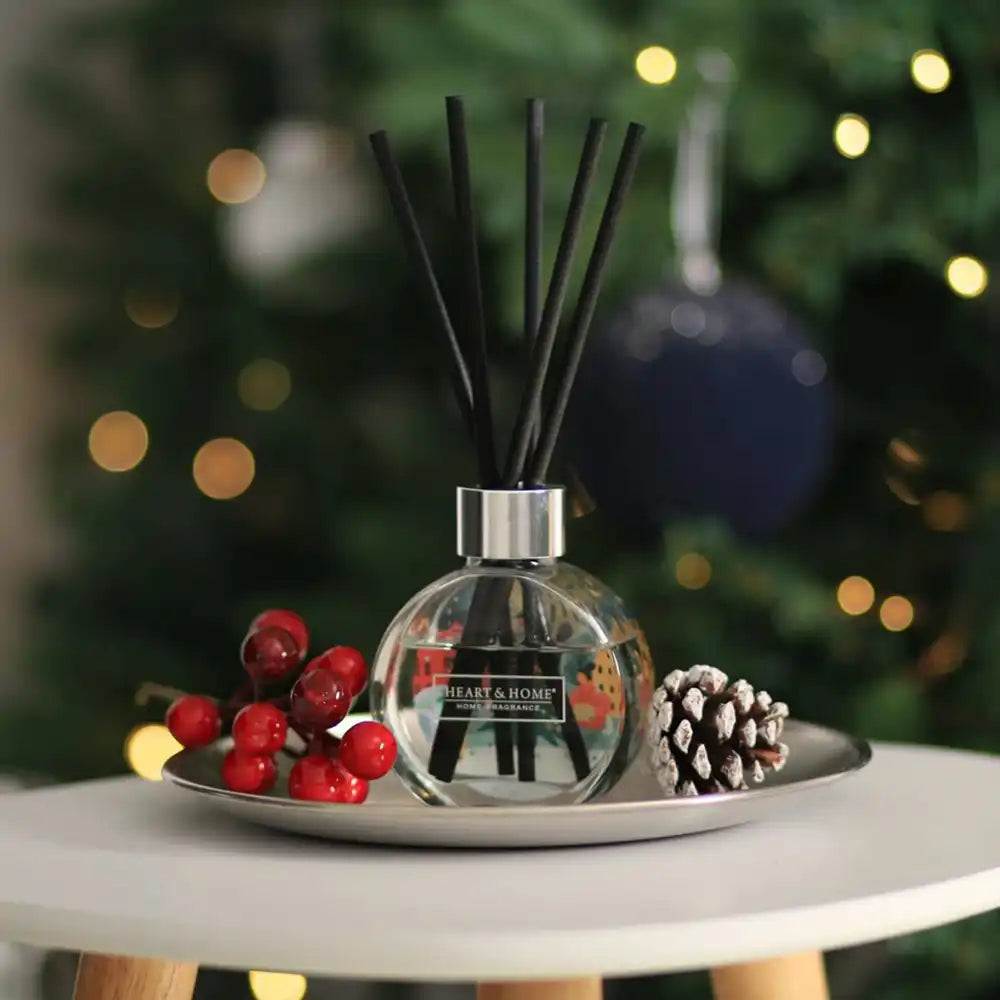 Diffuser with reeds on a tray in front of a decorated Christmas tree