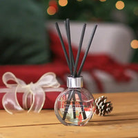 Diffuser with reeds on a wooden surface with a festive background