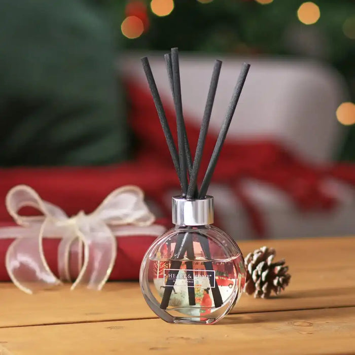 Diffuser with reeds on a wooden surface with a festive background