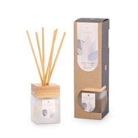 Diffuser with wooden sticks and packaging on a white background