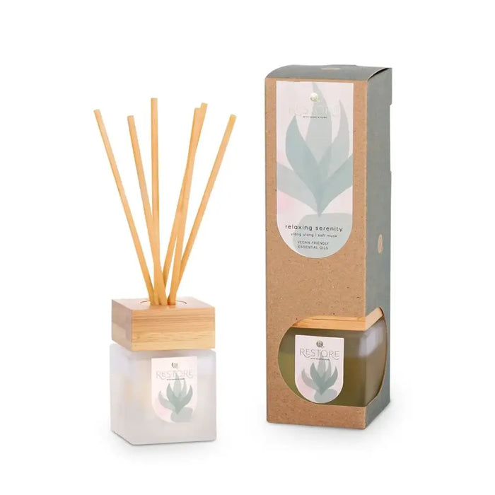 Reed diffuser with wooden holder and packaging on a white background