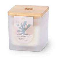 Square candle with a wooden lid. Glass jar is opaque and has a sticker on the front reading 'Blissful Oasis'.
