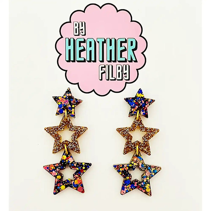 Star-shaped earrings with multicolor glitter on a white background with 'By Heather Filby' logo.