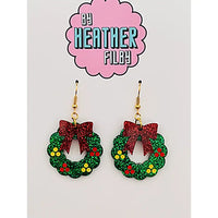 Christmas wreath earrings with red bows on a card with 'By Heather Filley' branding.