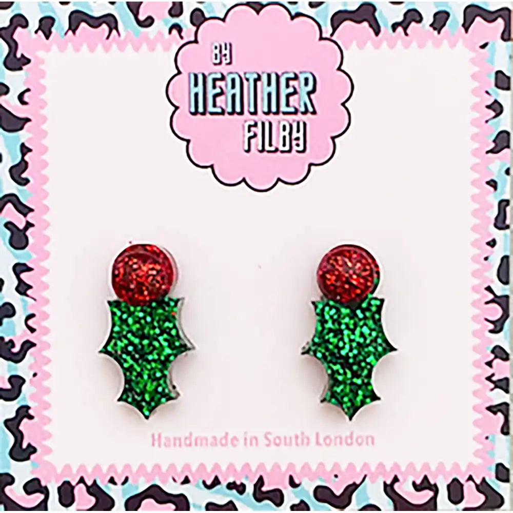 Pair of red and green glittery earrings on a patterned card with 'Heather Filby' branding.