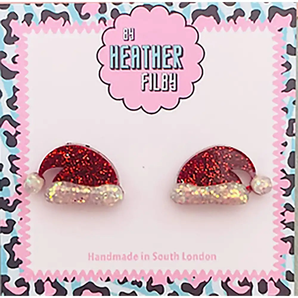 Red glittery Santa hat earrings on a branded card with 'Heather Filby' branding.