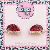 Red glittery Santa hat earrings on a branded card with 'Heather Filby' branding.