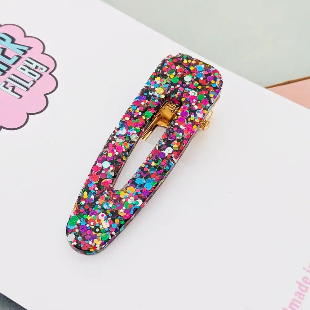 Multicolored confetti hair clip on a white surface