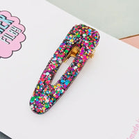 Multicolored confetti hair clip on a white surface