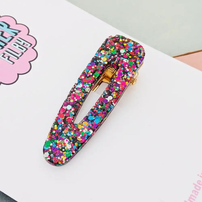 Multicolored confetti hair clip on a white surface