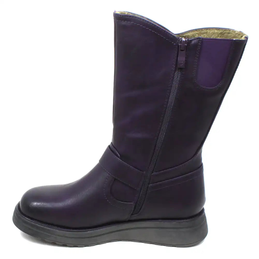 Heavenly Feet Bella purple calf height boots with goldie beige fleece lining. Wedge soles and strap across front of ankle with a purple buckle detail. Fitting is by zip on the inside of the boot and accompanied by a nearby elastic panel for comfort. View of single boot showing the purple zip and purple elasticated panel.