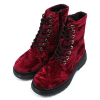 Red velour combat boots with rugged black soles and 8 hole laces. Fitted using zips. Angled view.