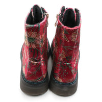 A pair of red velvet ankle boots with an embroidered floral pattern in green, gold, and brown, featuring dark brown soles and side zippers.