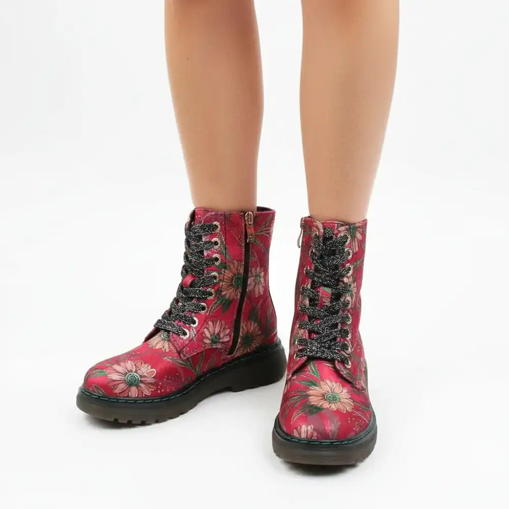Red floral lace-up ankle boots with black soles and black lace-up hardware, shown on a model's feet against a white background.
