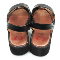 Black sandals with brown soles and red heart designs on a white background