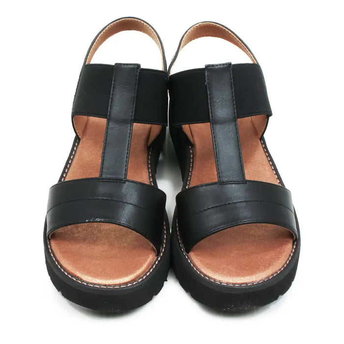 Pair of black sandals with brown soles on a white background