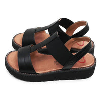 Black sandals with brown soles on a white background