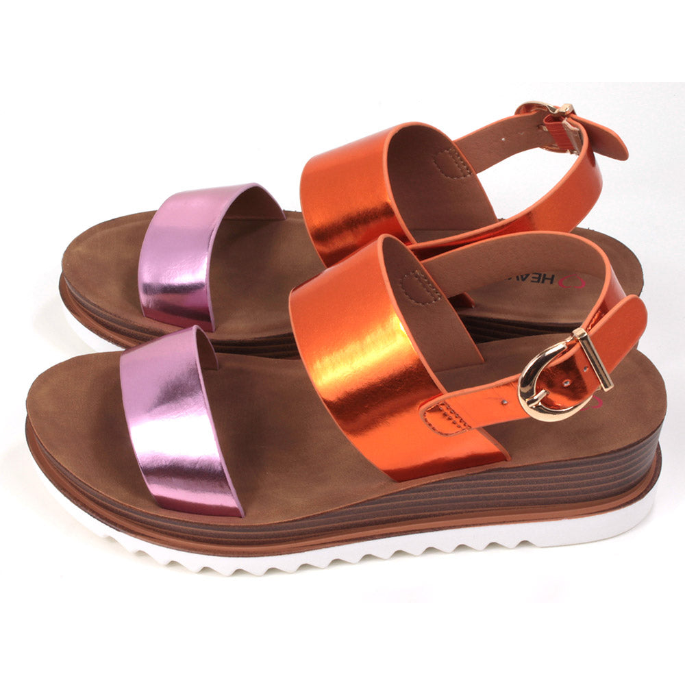 Pink and orange metallic effect sandals with buckled ankle strap. Two wide over the foot straps. Tan coloured footbed. White rubber soles. Side view