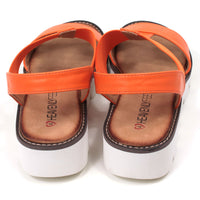 Orange low wedge sandals from Heavenly Feet. Over toes strap and upper foot elasticated strap. Strap around the back of the heel. Tan coloured footbeds. White low wedge soles with wide deep carved tread. Back view.