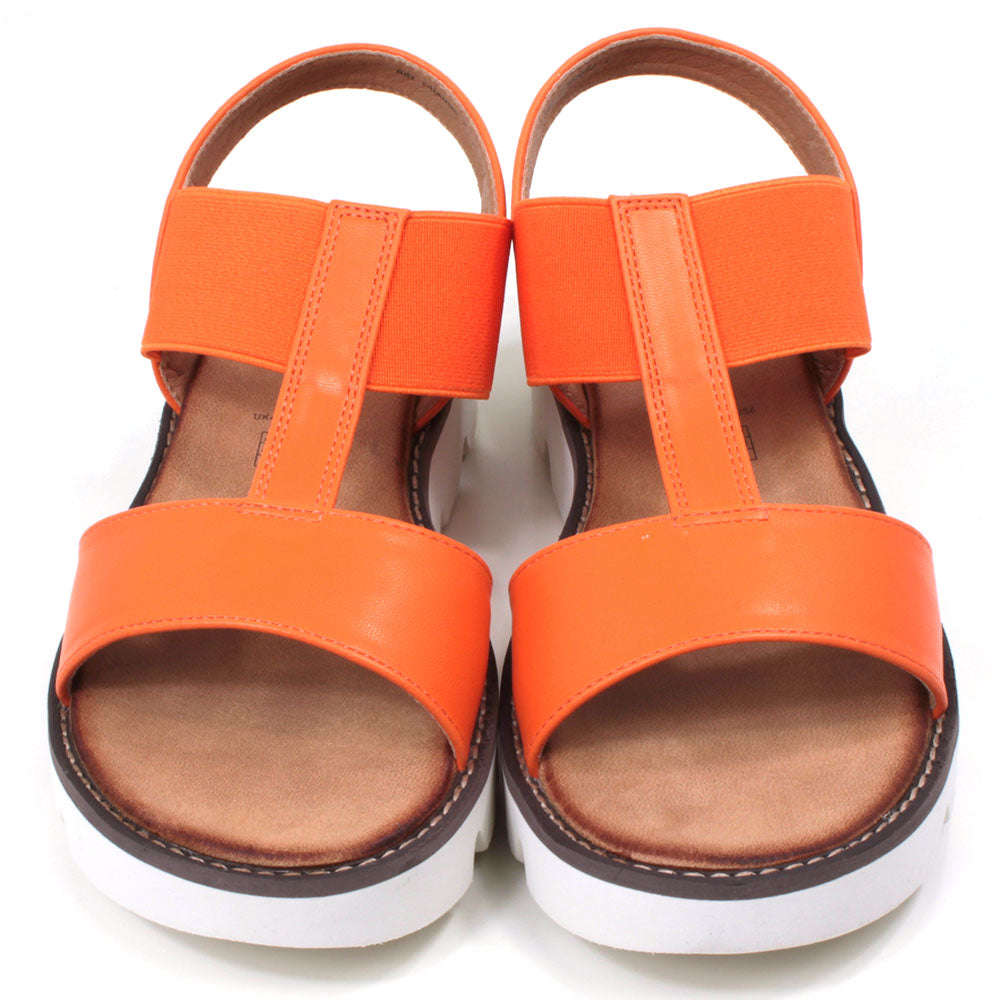 Orange low wedge sandals from Heavenly Feet. Over toes strap and upper foot elasticated strap. Strap around the back of the heel. Tan coloured footbeds. White low wedge soles with wide deep carved tread. Front view.