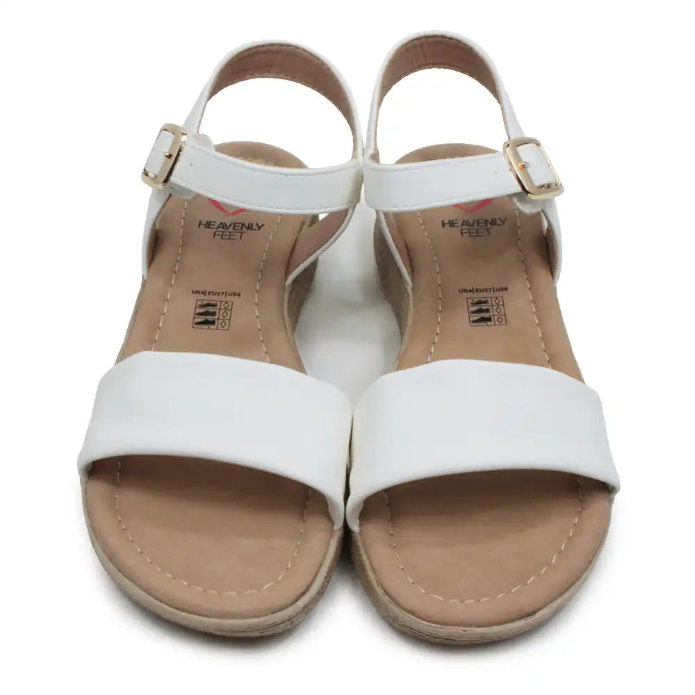 Pair of white sandals with tan soles on a white background
