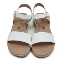 Pair of white sandals with tan soles on a white background