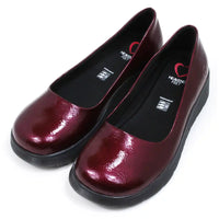 Pair of patent maroon slip on shoes with black low wedge soles. Round toes. Angled view.