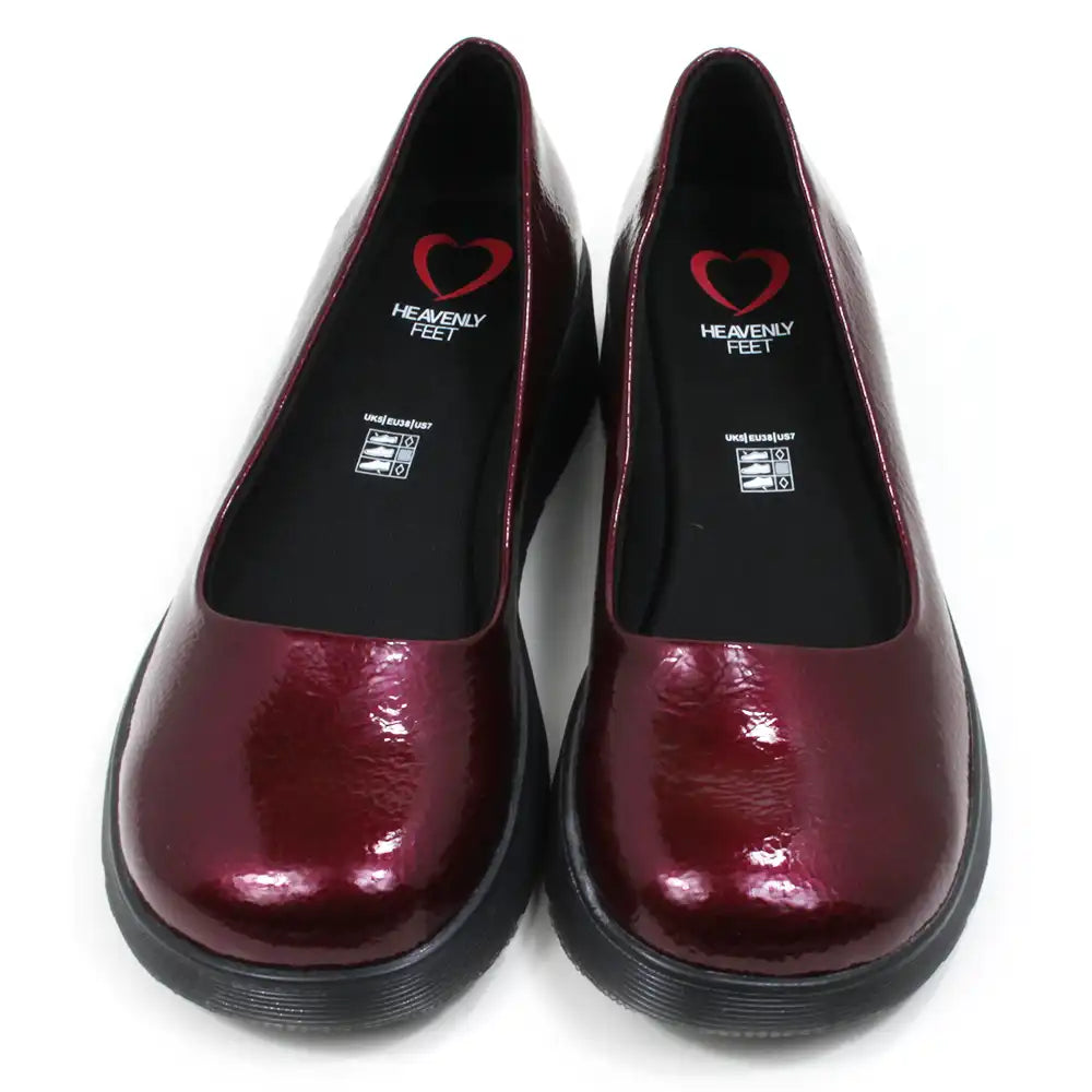 Pair of patent maroon slip on shoes with black low wedge soles. Round toes. Front view.
