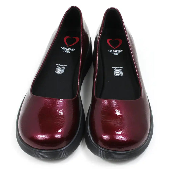 Pair of patent maroon slip on shoes with black low wedge soles. Round toes. Front view.