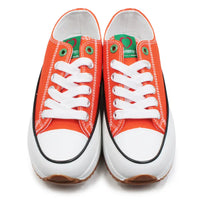 Pair of orange sneakers with white laces on a white background