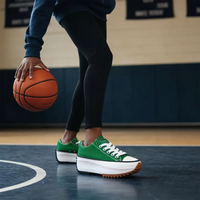 Person holding a basketball wearing green sneakers on a court