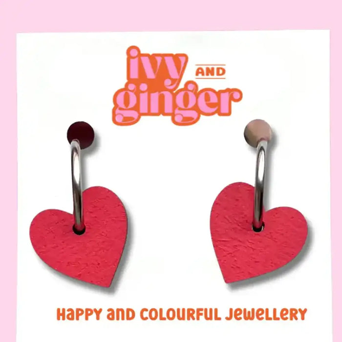 Red heart-shaped earrings on a card with 'Ivy and Ginger' branding on a pink background