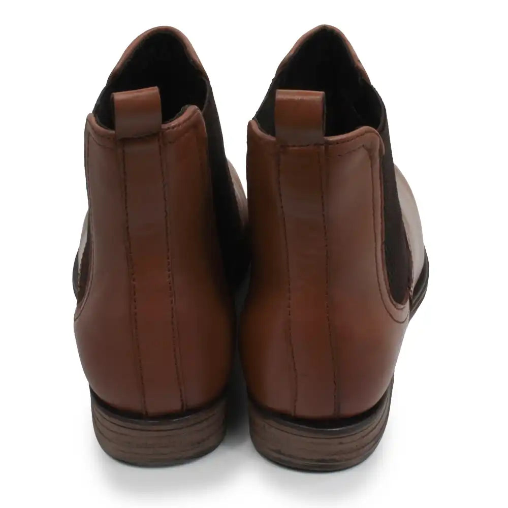 A pair of brown leather Chelsea boots shown from the back, featuring a smooth brown leather upper with elastic side panels and pull tabs, set against a plain white background.