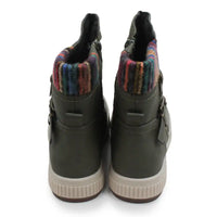 A pair of women's mid-calf boots shown from the back, featuring dark olive green leather uppers with side buckle details, a thick beige sole, and a vibrant multicolor striped knit collar lining.