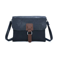 Navy satchel bag with a brown tab and silver hoop detail. On a white background 