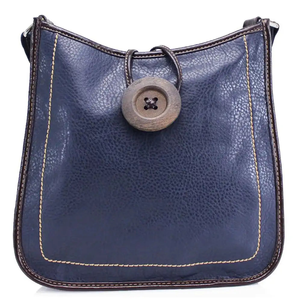 A navy blue pebbled leather shoulder bag with dark brown trim, light beige contrast stitching, and a large round wooden button closure on the front.