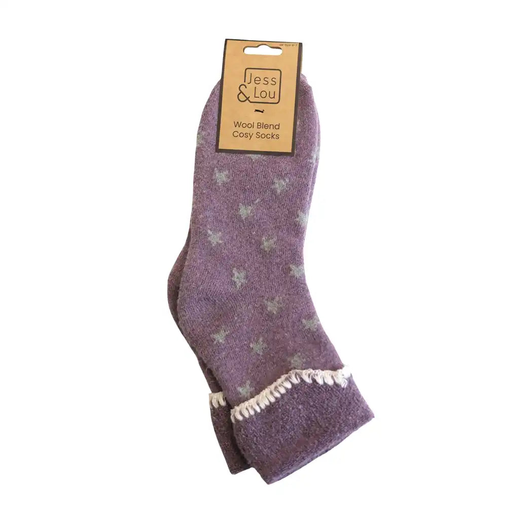 A pair of purple wool blend cozy socks with a light grey star pattern and white tassel trim, shown on a white background with a cardboard hanger.