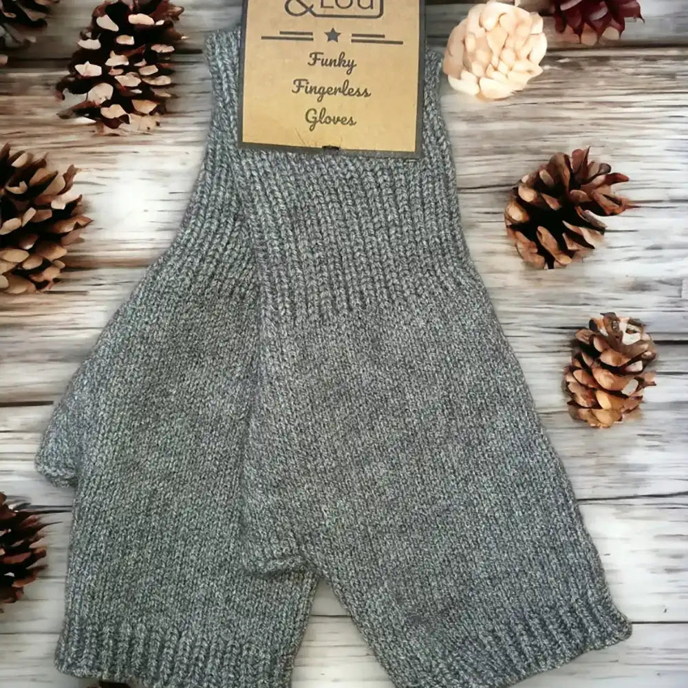 A pair of gray knit fingerless gloves laid flat on a whitewashed wood surface, with pinecones around them and a paper tag reading 'O'Leary Funky Fingerless Gloves.'.